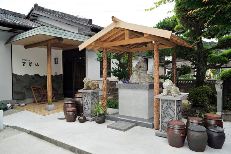 ギャラリー ペクパソンの正面。屋根の下に百婆仙追慕像、周りに大きな甕が並ぶ